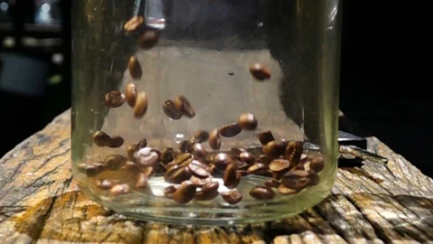 Falling coffee beans into glass jar, slow motion shot Stock Footage 104808433