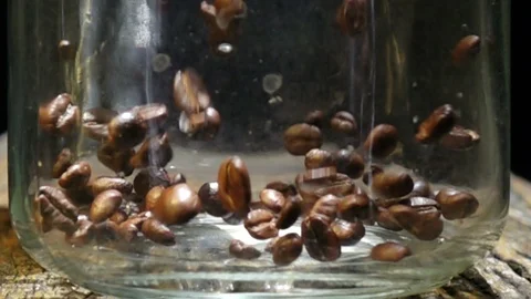 Falling coffee beans into glass jar, slow motion shot Stock-Footage 104808654