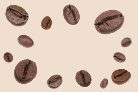 Falling coffee beans isolated on background. Flying defocused coffee beans. U Stock Photos
