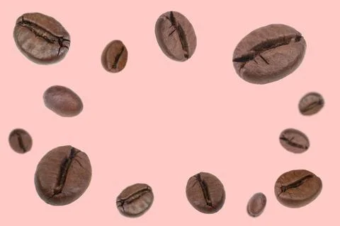 Falling coffee beans isolated on background. Flying defocused coffee beans. U Stock Photos