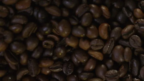 Falling coffee beans in slow motion. Smoke emanates from fresh coffee beans Stock Footage 324858847