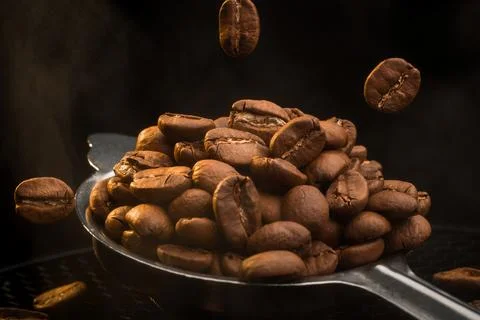 Falling Coffee Beans into Spoon with Steam Stock Photos