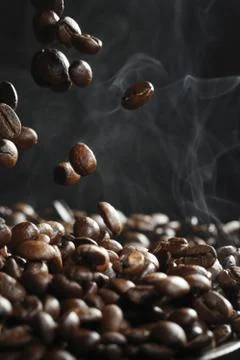 Falling coffee beans with steam Stock Photos