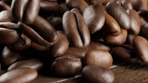Falling coffee beans on a wooden table. Falling coffee beans into a pile. Stock Footage 249522806