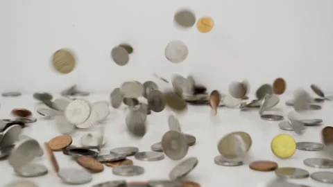 Falling coins in slow motion, on a white table Stock Footage