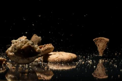 Falling Cookies On Black Background Stock Photos