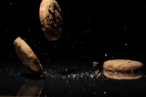 Falling Cookies On Black Background Stock Photos