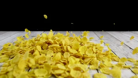 Falling corn flakes on wooden table in slow motion Stock Footage 140234383