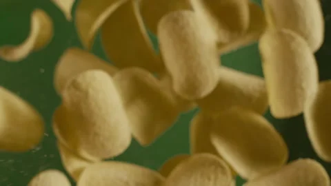 Falling crispy golden potato chips in slow motion Stock Footage 143782995