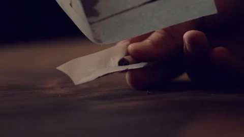 Falling of a crushed marijuana falls on a tissue paper with filter to make joint Stock Footage 162500406