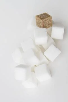 Falling cubes stack of white sugar cube with one brown sugar cube falling ... Stockfoto's