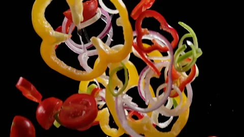 Falling cuts of plenty colorful vegetables isolated on black background. 库存影片 99322779