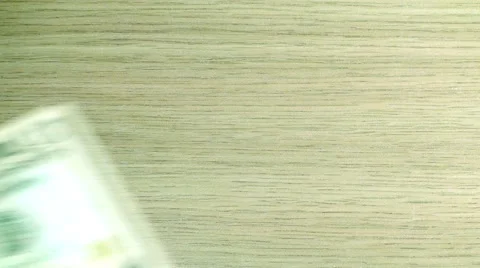 Falling dollar bills of different denominations and coins on wooden background Stock Footage 61202895