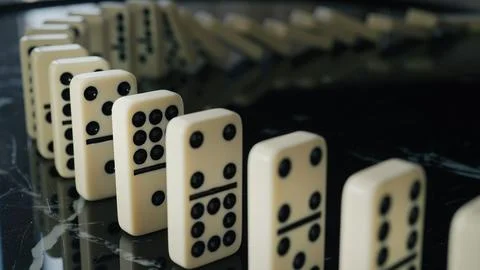 Falling domino pieces trigger a continuous chain reaction. Symbol of cause .. Foto stock