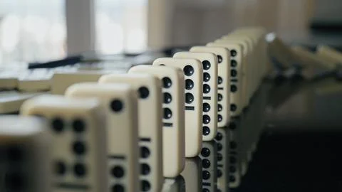 Falling domino pieces trigger a continuous chain reaction. Symbol of cause .. Foto stock