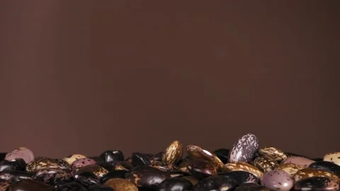 Falling down bean beans on a brown background. Super slow-motion. Stock Footage 150182843