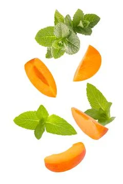 Falling down mint herb and apricots isolated on white background Stock Photos