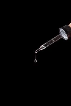 The falling drop of transparent liquid isolated on the black background Stock-Fotos