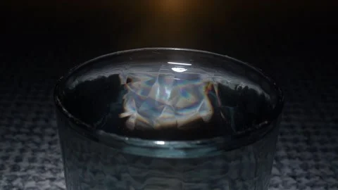 Falling Drop of Water into a glass against a black background. Slow motion Stock Footage 233962011