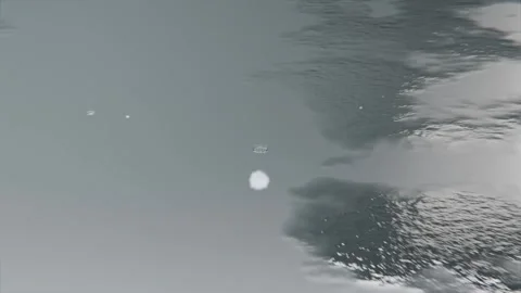 Falling droplet creating crown on reflective bluish-gray water, forming bead Stock Footage 341865092