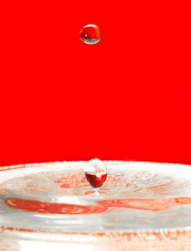 Falling droplets of water over red Ilustração Stock
