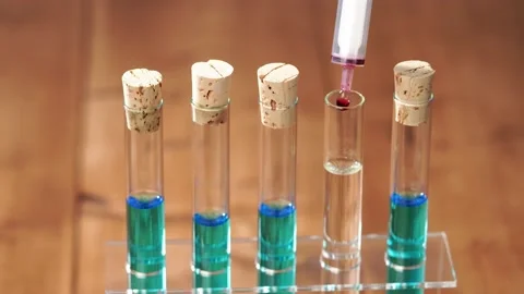 Falling drops of red liquid in laboratory glass, chemical experiment. Stock Footage 156582494