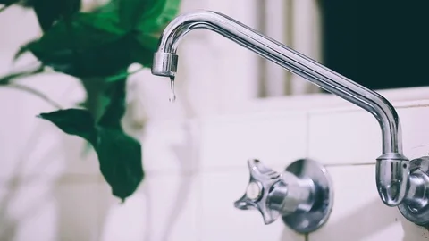 Falling drops from silver tap. Water dripping close-up. Leaking tap. Waisting wa Stock Footage 125114870