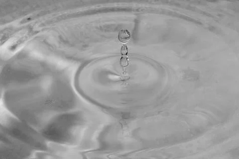 Falling drops in water Stock Photos
