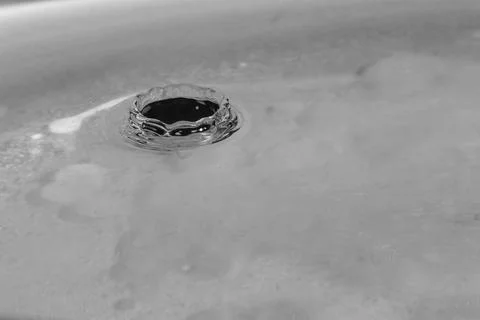 Falling drops in water Stock Photos