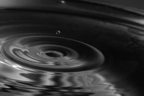 Falling drops in water Stock Photos