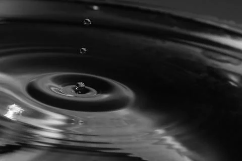 Falling drops in water Stock Photos