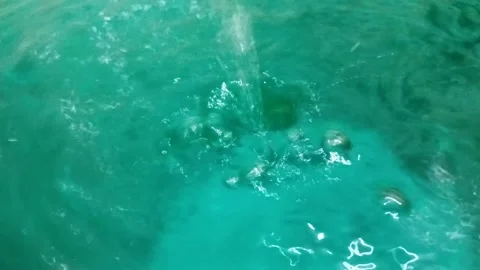 Falling drops of water on the surface of a clear clear liquid Stock Footage 202133732