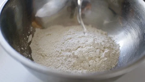 Falling egg into bowl with flour. Stock Footage 105350807