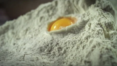 Falling egg into the dough in slow motion Stock Footage 256936832