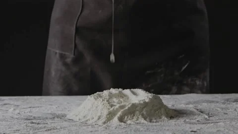 Falling egg into pile of flour on a black background. Process of preparing dough Stock Footage 131443872
