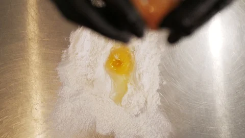 Falling eggs into flour stock. Egg dropping into flour. Stockbeeldmateriaal 108685496