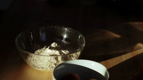 Falling eggs into flour. Sun light slowmotion Stock Footage 70942276