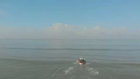 Falling follow Drone shot of small colourful indian fishing boat going out Video stock 141492771