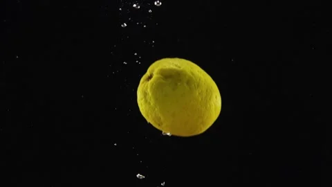 Falling fresh citrus lemon splashing water on black background Stock Footage 293086026