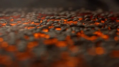 Falling fresh coffe beans form a pile on a roasting platform Stock Footage 129493615