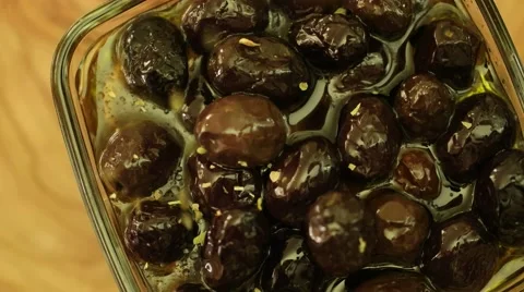 Falling fresh thyme leaves on to black olives on rotate Stock-Footage 61800155