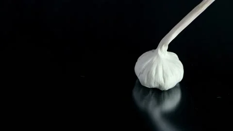 Falling garlic isolated on dark background Stock Footage 132917359