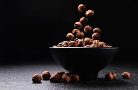 Falling hazelnuts on black background with copy space Foto stock