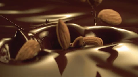 Falling hazelnuts in liquid chocolate in slow motion Stock Footage 256938565