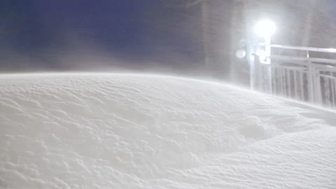 Falling heavy snow against the night sky illuminated by the lights of the city. Stock Footage 121576819