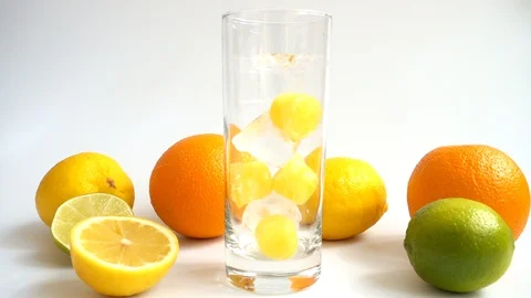 Falling ice and ice from orange juice into a glass. Slow motion. Stock Footage 129567074