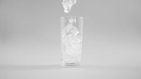 Falling ice cube into glass on white background Stock Footage 123914234