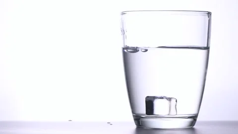 Falling ice cubes into a glass with clear water with splashing Stock Footage 169396560