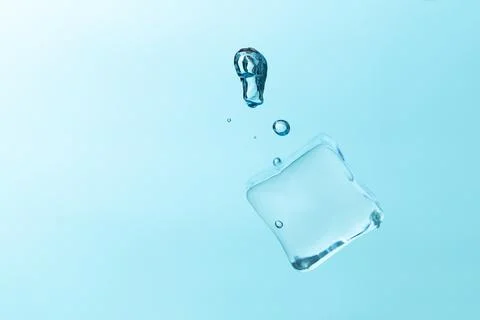 Falling ice cubes in water splashes isolated on blue background. Stock Photos
