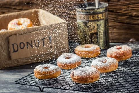 Falling icing sugar on fresh donuts Stock Photos